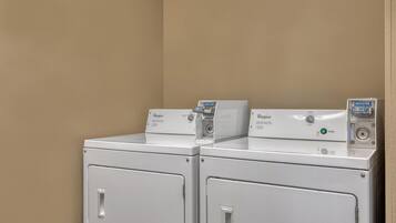 Two front-loading Whirlpool washers in a corner with beige walls.