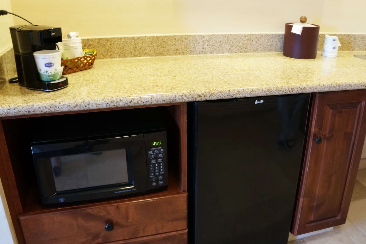 A compact kitchen with a microwave, dishwasher, coffee maker, and a sink.