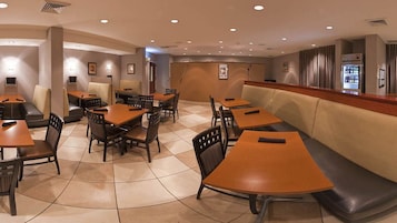 Un restaurante con cabinas, mesas y una barra.