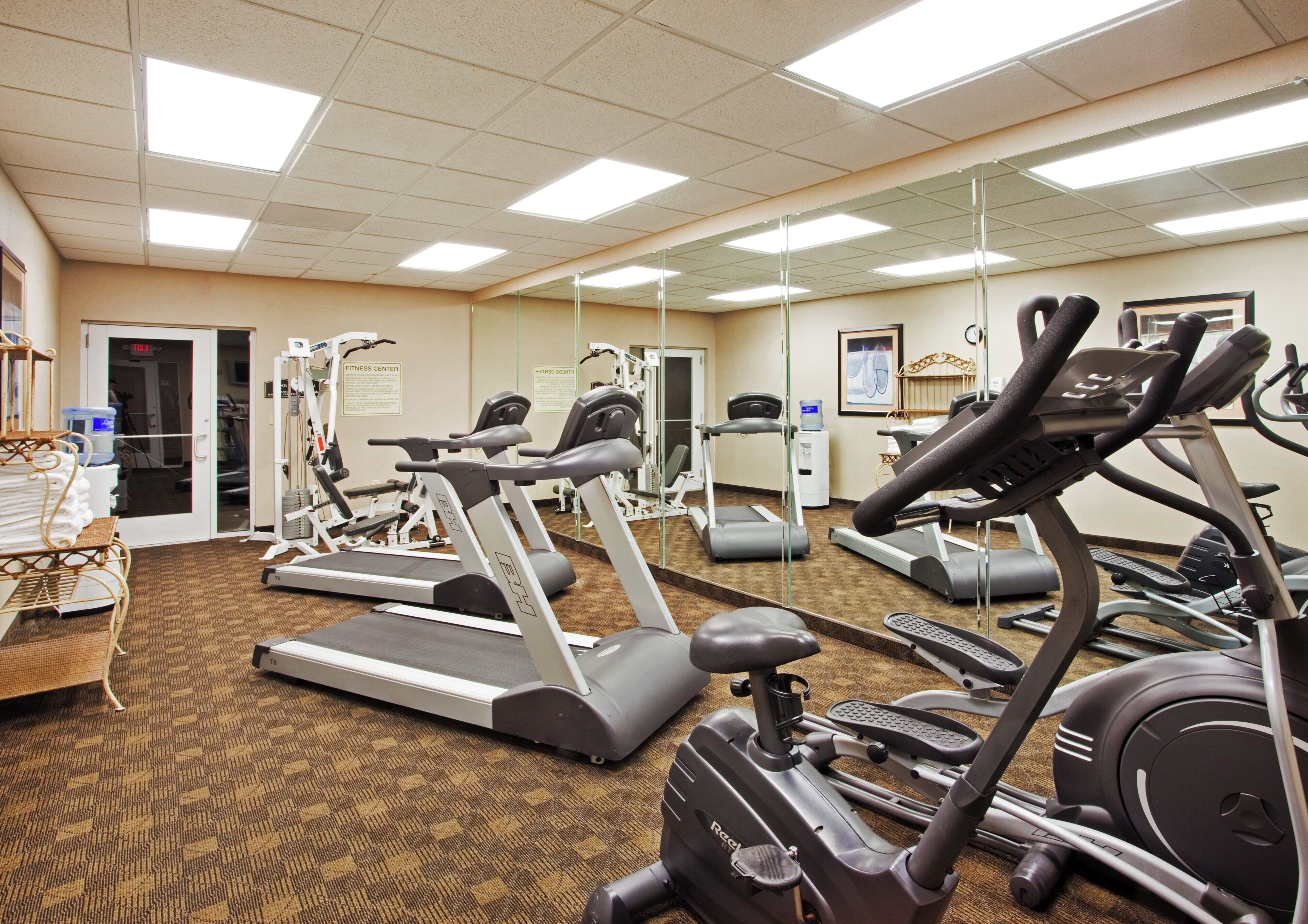 A fitness center with treadmills, elliptical machines, and weight equipment.