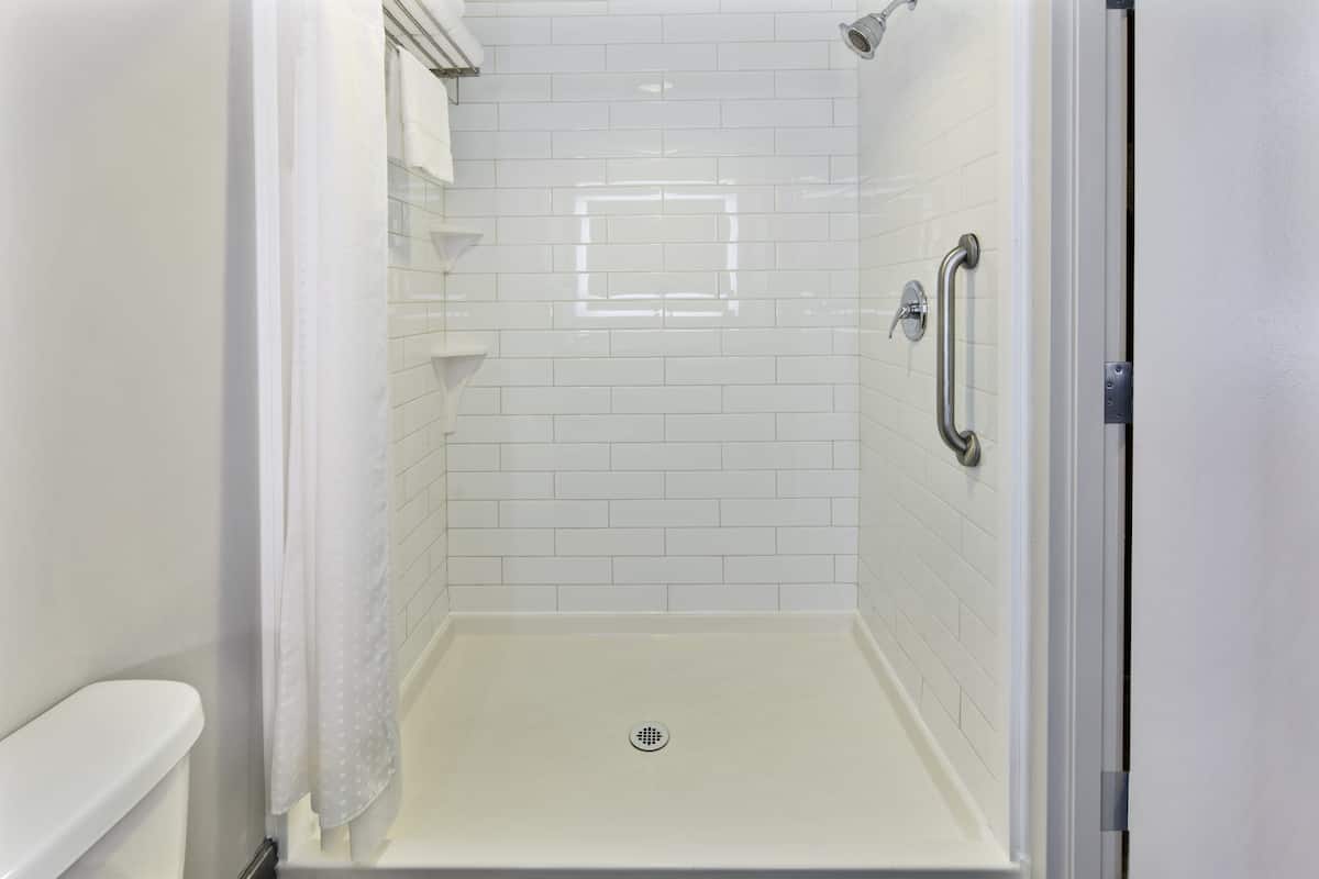suite, 1 king bed, roll-in shower (communications) | bathroom | hair dryer, towels, soap, shampoo