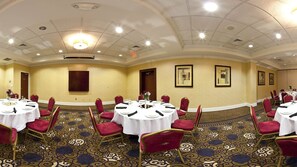 A conference room with round tables, red chairs, and a patterned carpet. - Holiday Inn Augusta West I-20 by IHG (Grovetown)