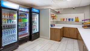A clean, modern room with two beverage dispensers, a white counter, and a wall-mounted snack rack. - Holiday Inn Express Hotel & Suites Salisbury - Delmar by IHG (Delmar)