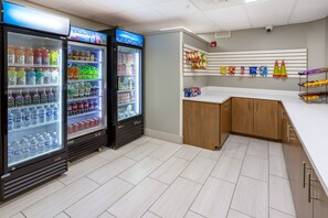 A clean, modern room with two beverage dispensers, a white counter, and a wall-mounted snack rack. - Holiday Inn Express Hotel & Suites Salisbury - Delmar by IHG (Delmar)