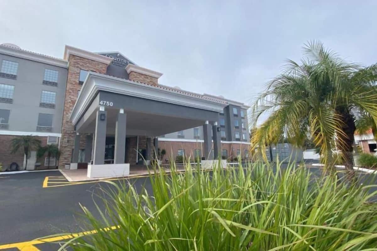 A hotel entrance with a covered area, numbered 4750, and a parking lot with yellow lines.