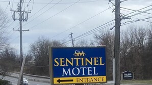 En skylt för ett motell med en pil som pekar åt vänster, mot entrén.