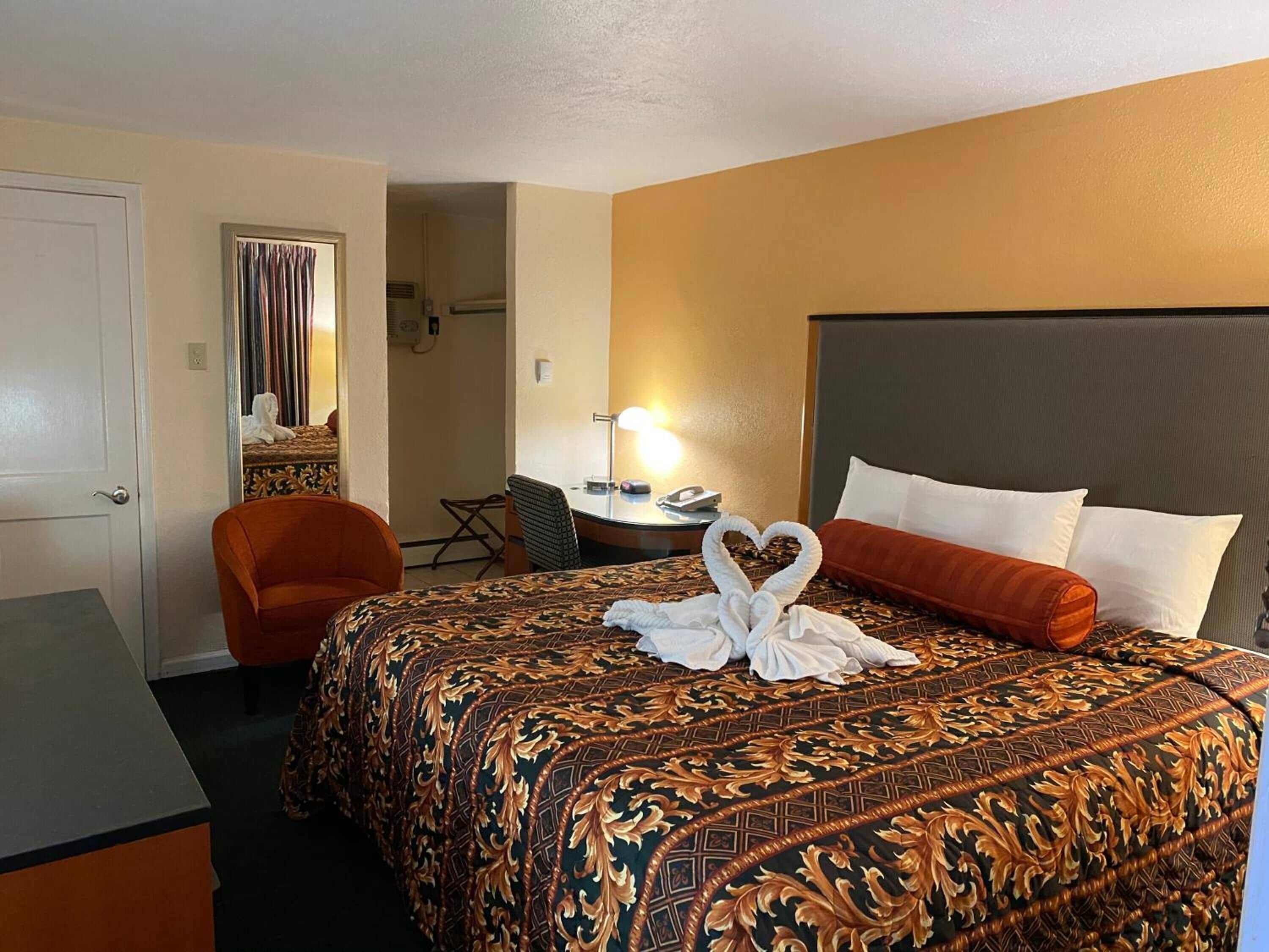 Una habitación de hotel con una cama grande, un escritorio y una silla.