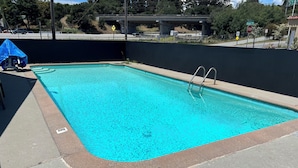 A rectangular swimming pool with a metal ladder on one side, surrounded by a concrete deck. - National 9 Santa Cruz (Santa Cruz)