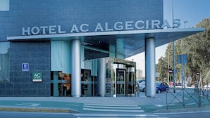 Uma entrada de hotel moderna com uma placa visível indicando "HOTEL AC ALGECIRAS".