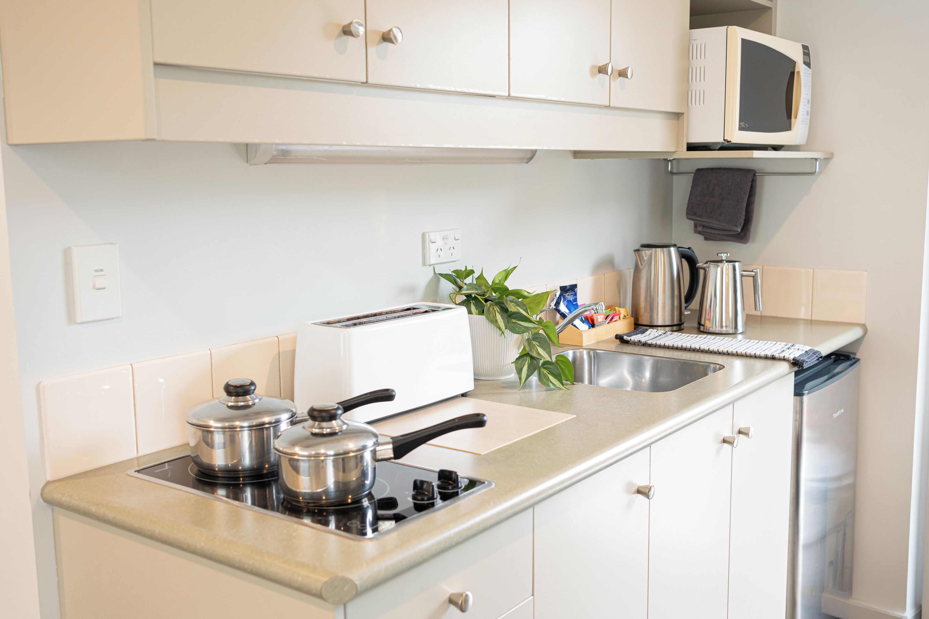 A kitchen with a stove, toaster, microwave, and cabinets.