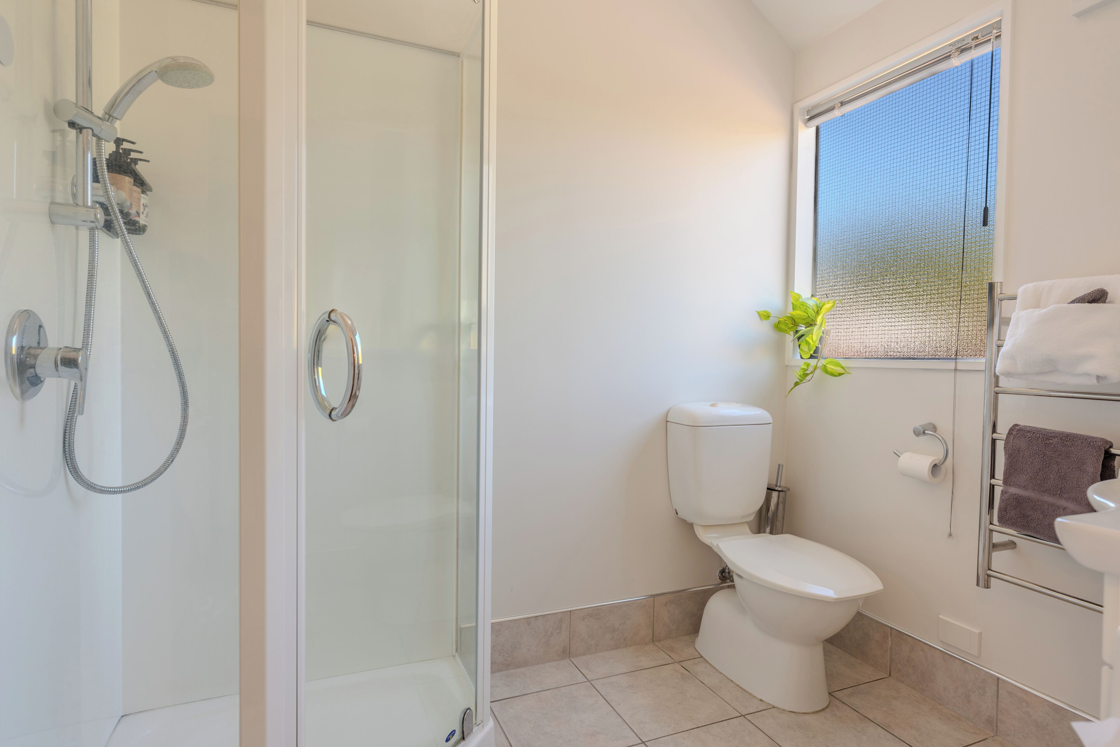 Un baño moderno con ducha de vidrio, inodoro y lavabo.