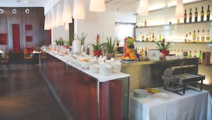 Een buffetopstelling met diverse gerechten en een drankbar.
