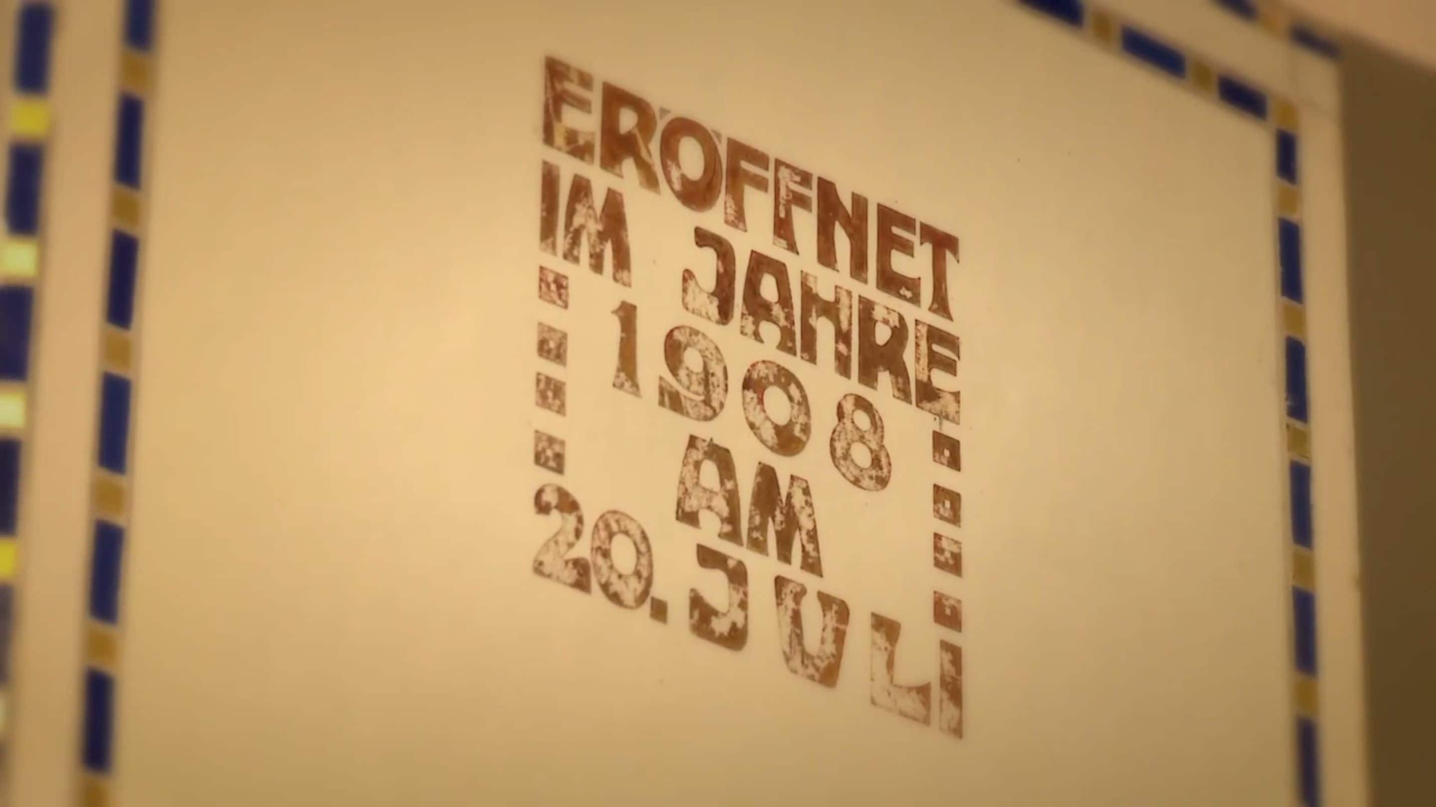 Paredes com o texto "EROFFNET IM JANKE 1908 AM 20.07.21".