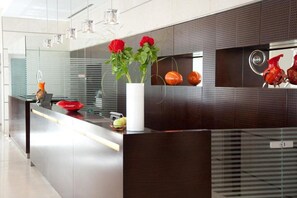 Cozinha moderna com ilha elegante, painel de vidro e luminárias pendentes.