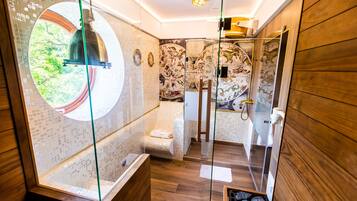 Une salle de bain moderne avec une douche à parois de verre, un meuble-lavabo en bois et une grande fenêtre circulaire.