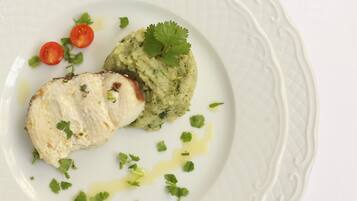 Une assiette contenant un morceau de poisson, de la purée de pommes de terre et des accompagnements.