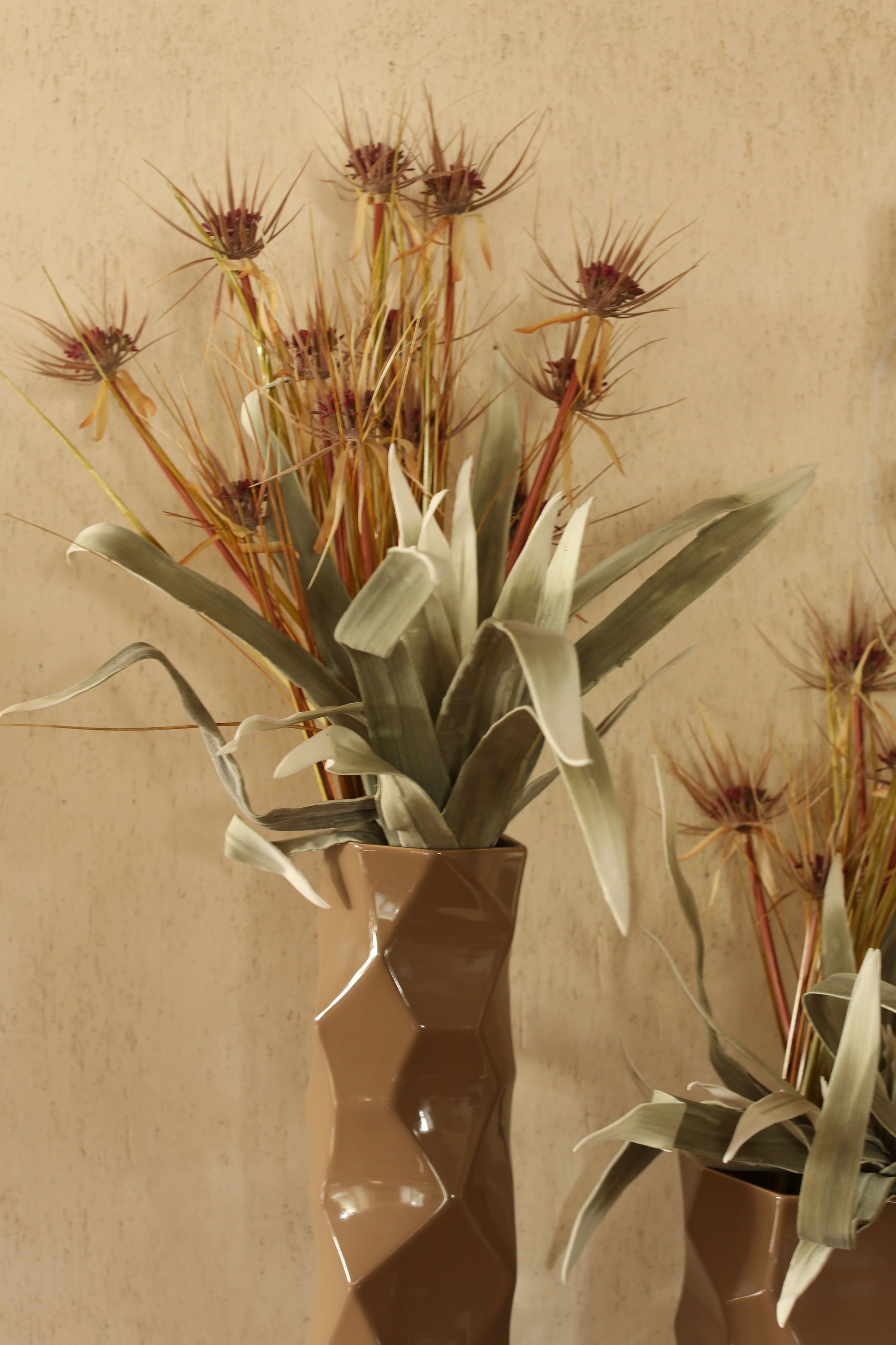 A potted plant with long, slender leaves and a brown vase.
