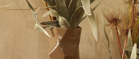A potted plant with long, slender leaves and a brown vase.