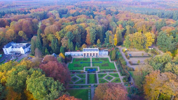An aerial view of a large estate with a central building surrounded by manicured gardens and a forested area. - Landgoed Hotel Groot Warnsborn (Arnhem)