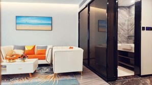 Uma sala de estar moderna com sofá, mesa de centro e uma pintura na parede.