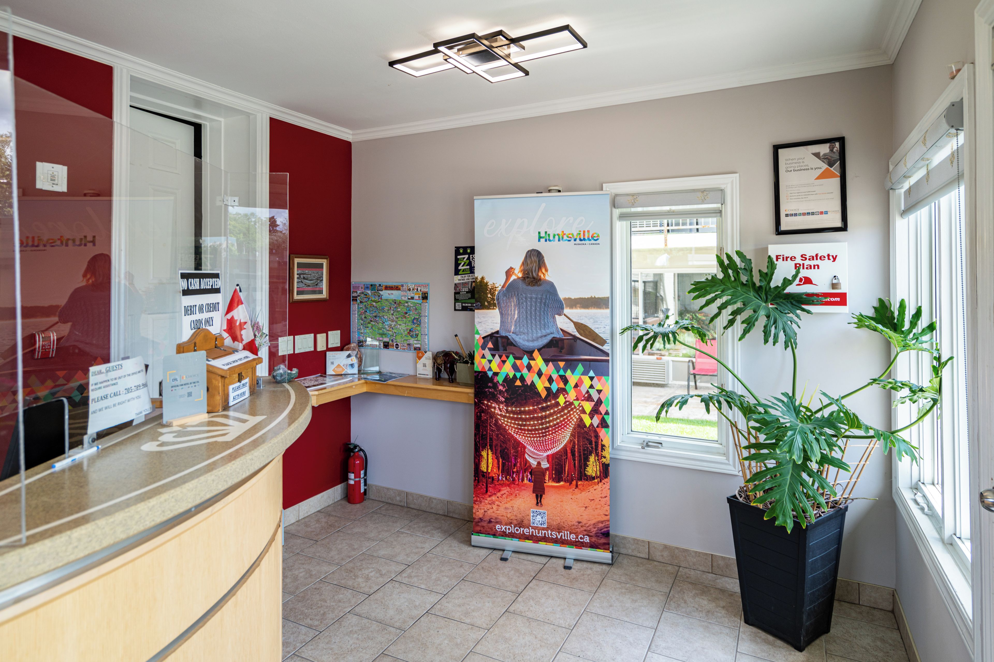 Een receptiezone met een balie, een bord met de brandveiligheidsvoorschriften, een plattegrond en een groot poster van iemand in een kano.