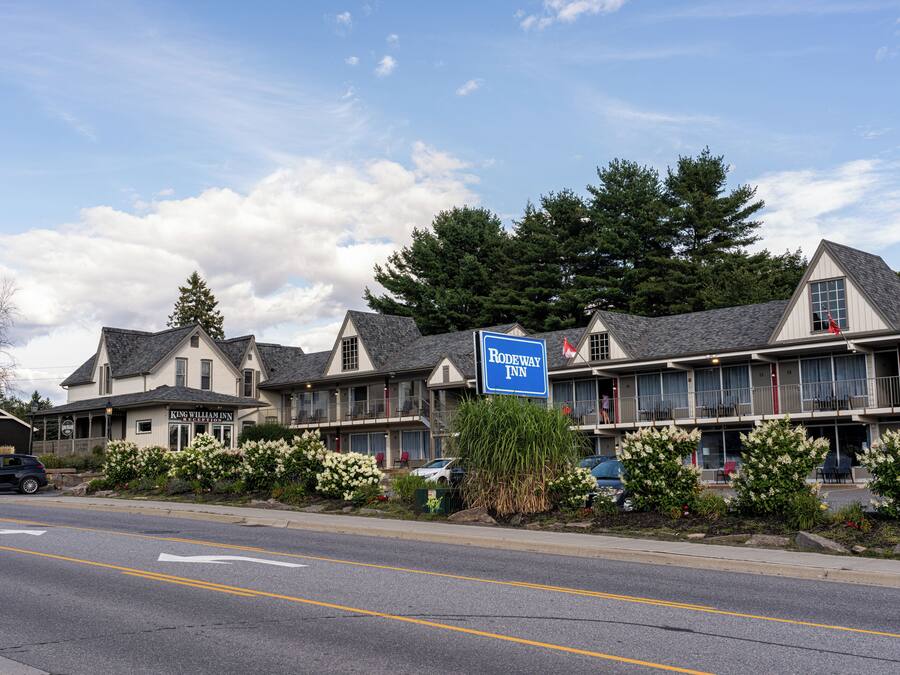 A motel with a reception area, multiple guest rooms, and a parking lot.