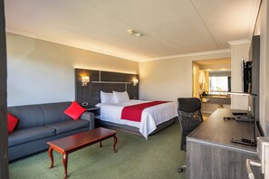 Una habitación de hotel con una cama, un sofá, un escritorio y una silla.