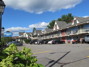 Un motel con edificios de varios pisos, un estacionamiento y una señalización visible del motel.