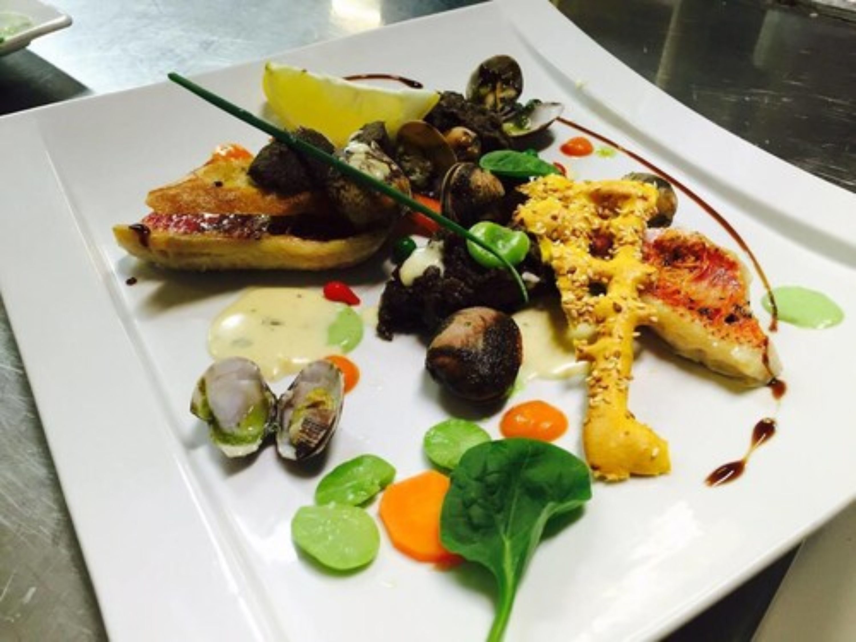 A white plate with various food items including a piece of grilled chicken, mushrooms, and greens.