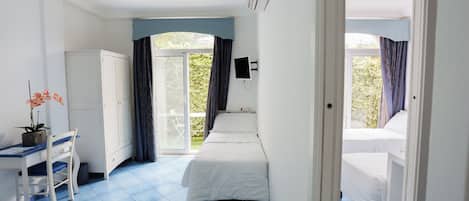 Una habitación con dos camas, un escritorio, una silla y un armario.