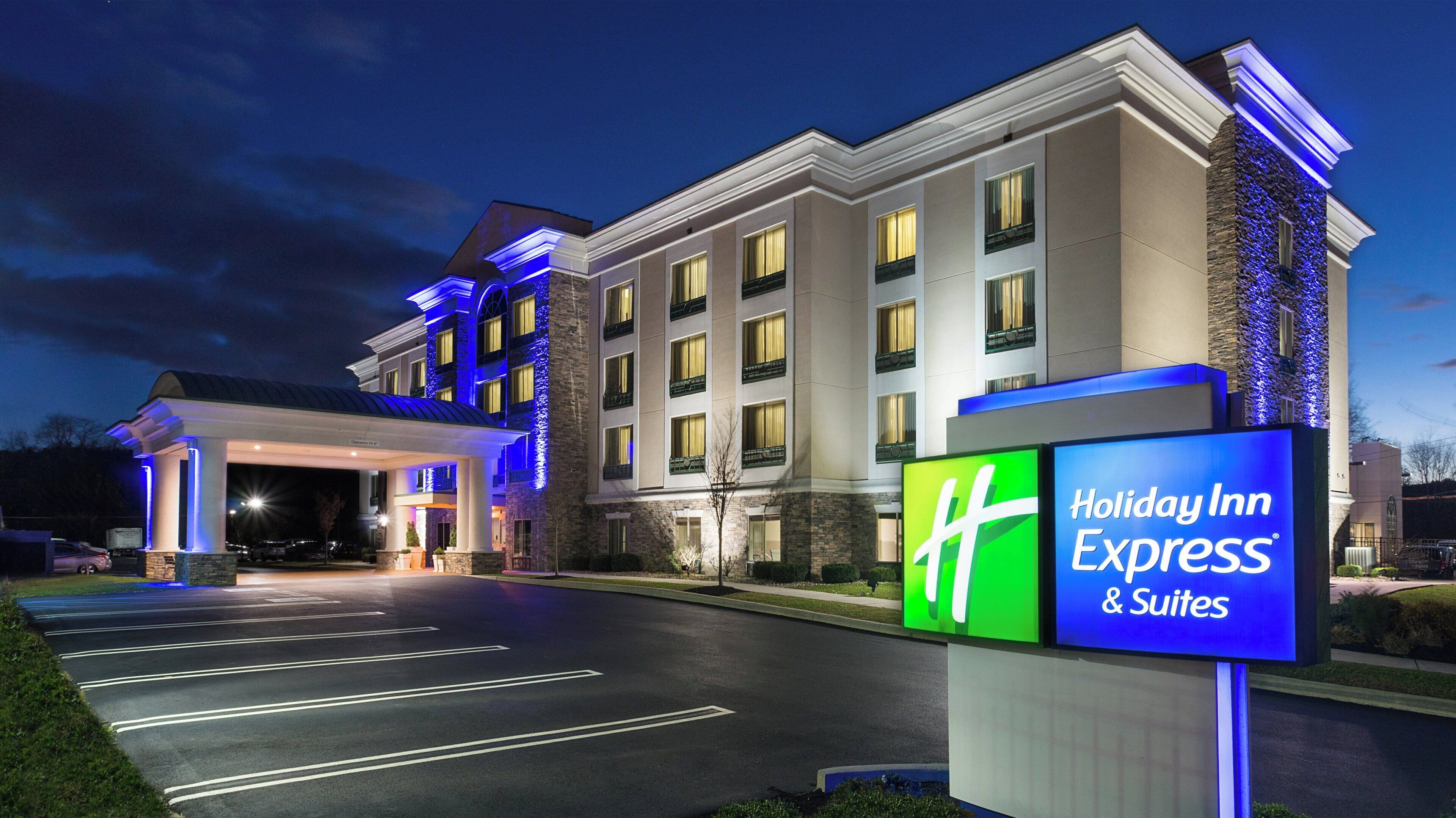 A Holiday Inn Express & Suites hotel with a well-lit entrance and a clear signboard.