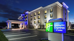 Een Holiday Inn Express & Suites hotel met een goed verlichte entree en een duidelijk bord.