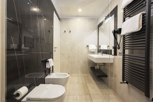 A modern bathroom with a toilet, bidet, and sink.