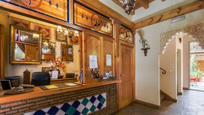 A reception desk with a check-in counter, a mirror, and a bulletin board. - Abadia Hotel Granada Centro (Granada)