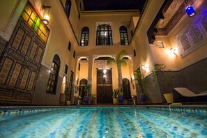Una piscina al aire libre, sillones reclinables de piscina