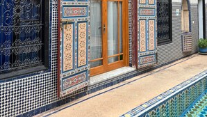 A building with intricate tile work, a wooden door, and a small balcony.