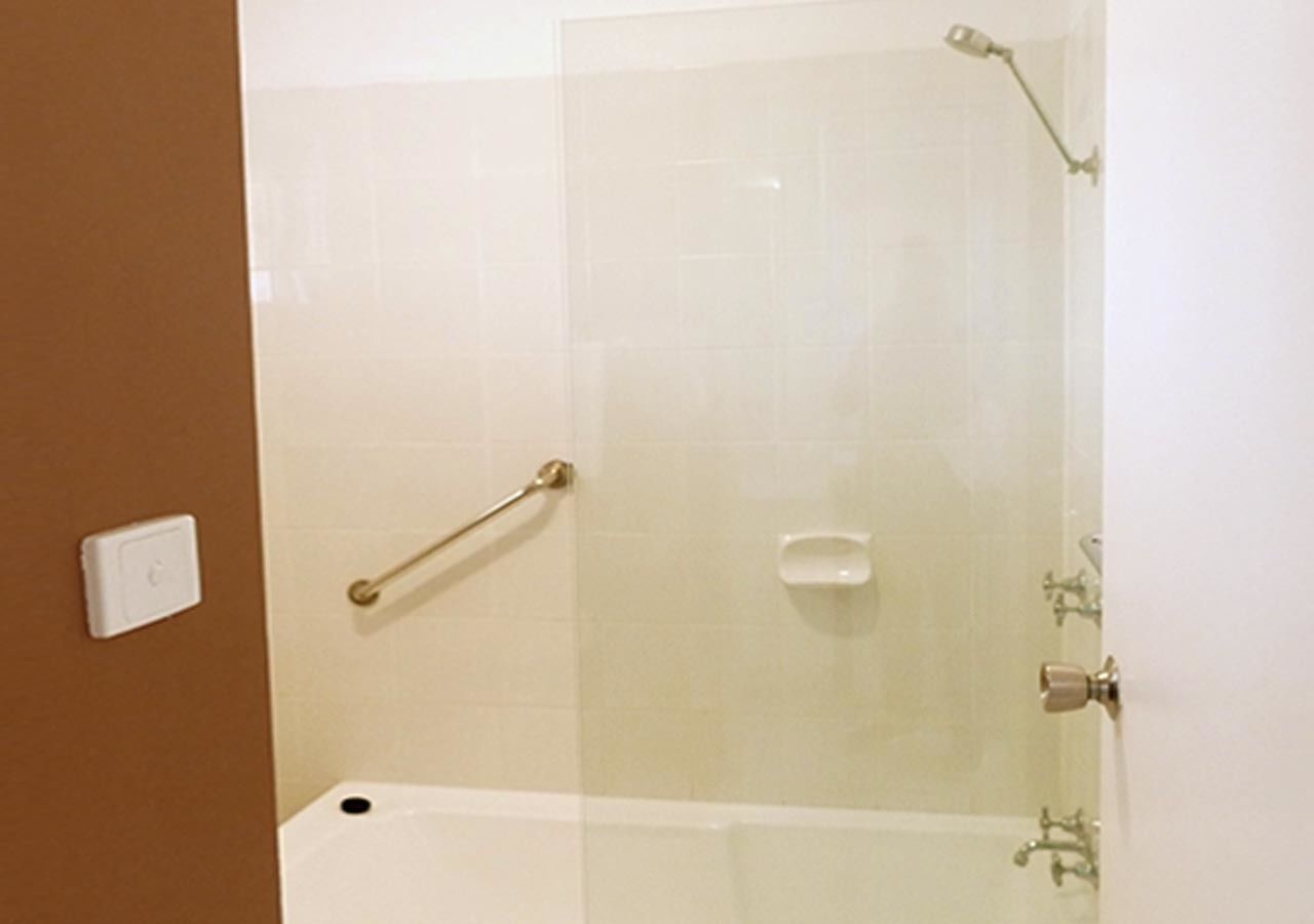 Un baño con ducha de vidrio, una bañera blanca y un perchero para toallas.