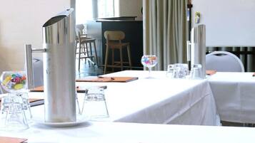 A conference room with tables set for a meeting, a water pitcher, and a glass pitcher on the table.