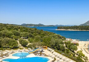Una piscina al aire libre, sombrillas, sillones reclinables de piscina