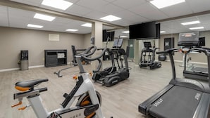 Ein Fitnessstudio mit verschiedenen Trainingsgeräten, darunter Laufbänder, Ergometer und Crosstrainer.