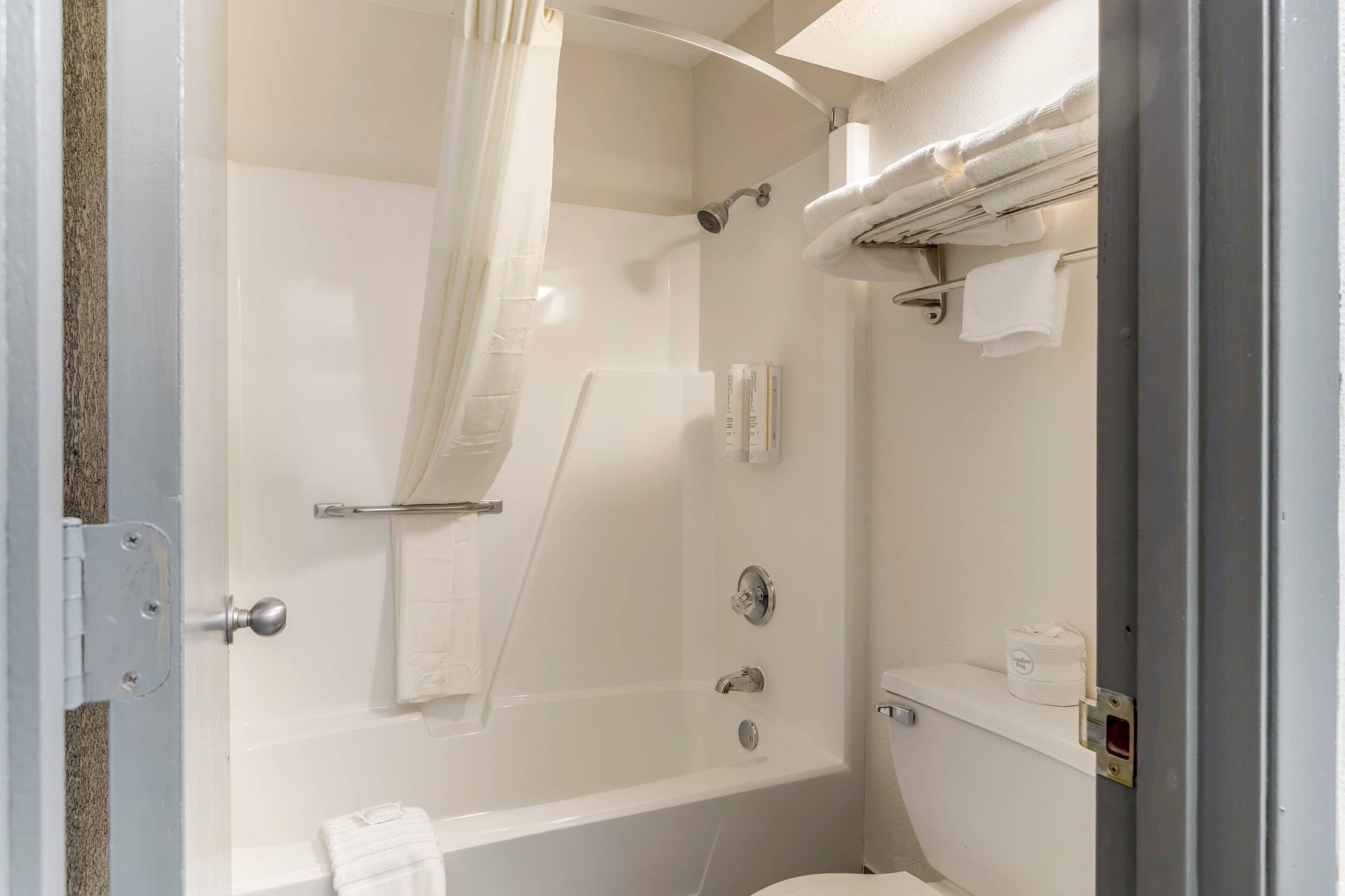 A bathroom with a bathtub, shower, and toilet.