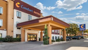A Comfort Suites hotel with a brick facade, a covered entrance, and a parking lot.