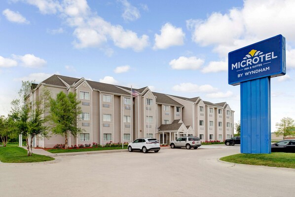 Edificio de Microtel Inn & Suites con un letrero grande, varios espacios de estacionamiento y un césped bien cuidado.