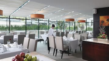 Un restaurant au décor moderne, où l’on peut voir un serveur s’occuper d’une table.