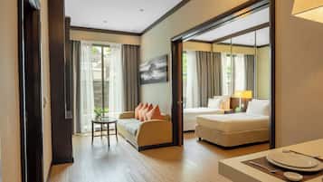 A hotel room with a sofa, a dining table with plates, a lamp, and a painting on the wall.
