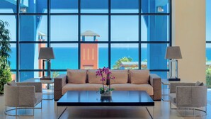 A modern living room with a large window, a sofa, two armchairs, a coffee table, and a potted orchid. - H10 Tindaya (Pajara)