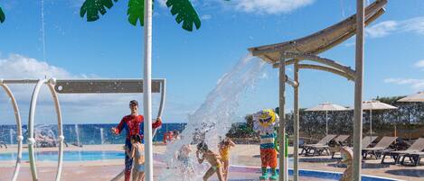 Uma área de recreação aquática com piscina, palmeiras e um baú do tesouro.