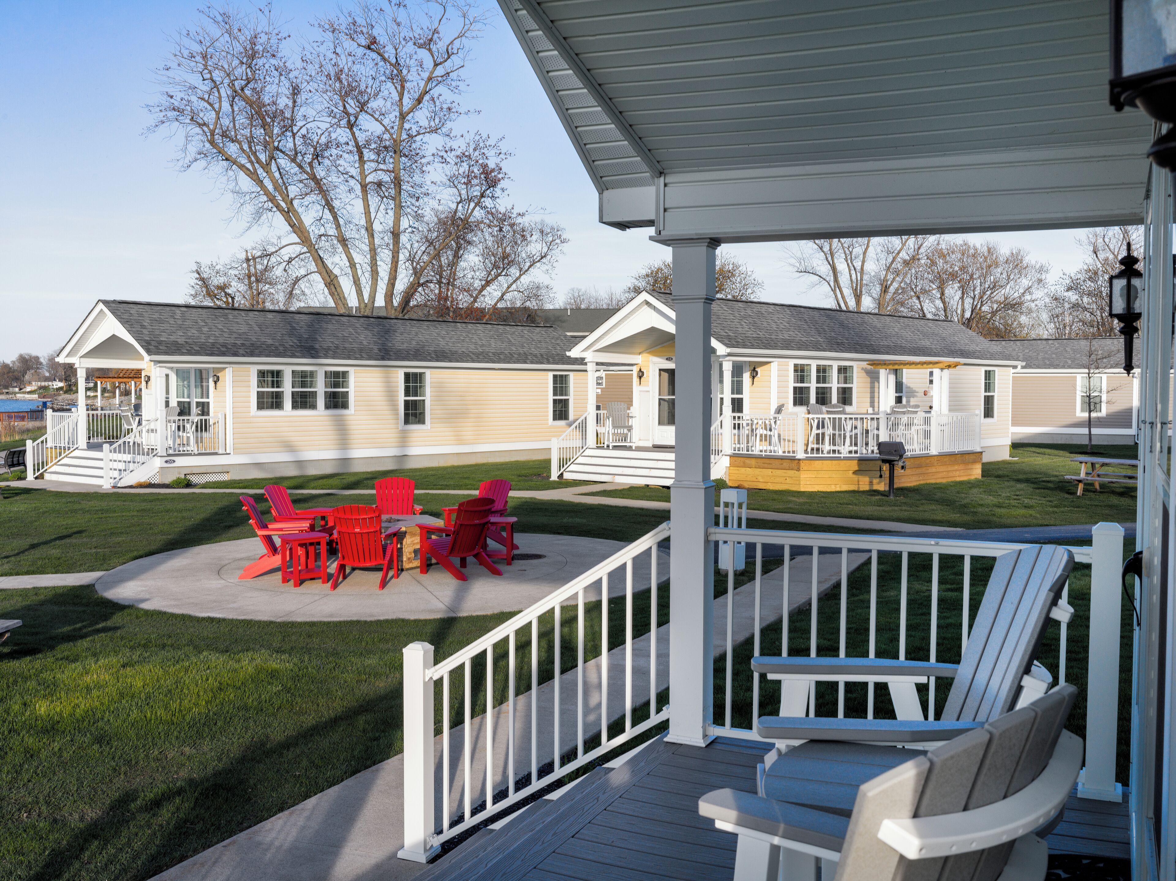 A covered outdoor area with a patio, red chairs, and a white deck.