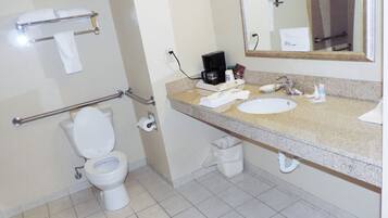 Baño con inodoro, lavabo y cafetera.