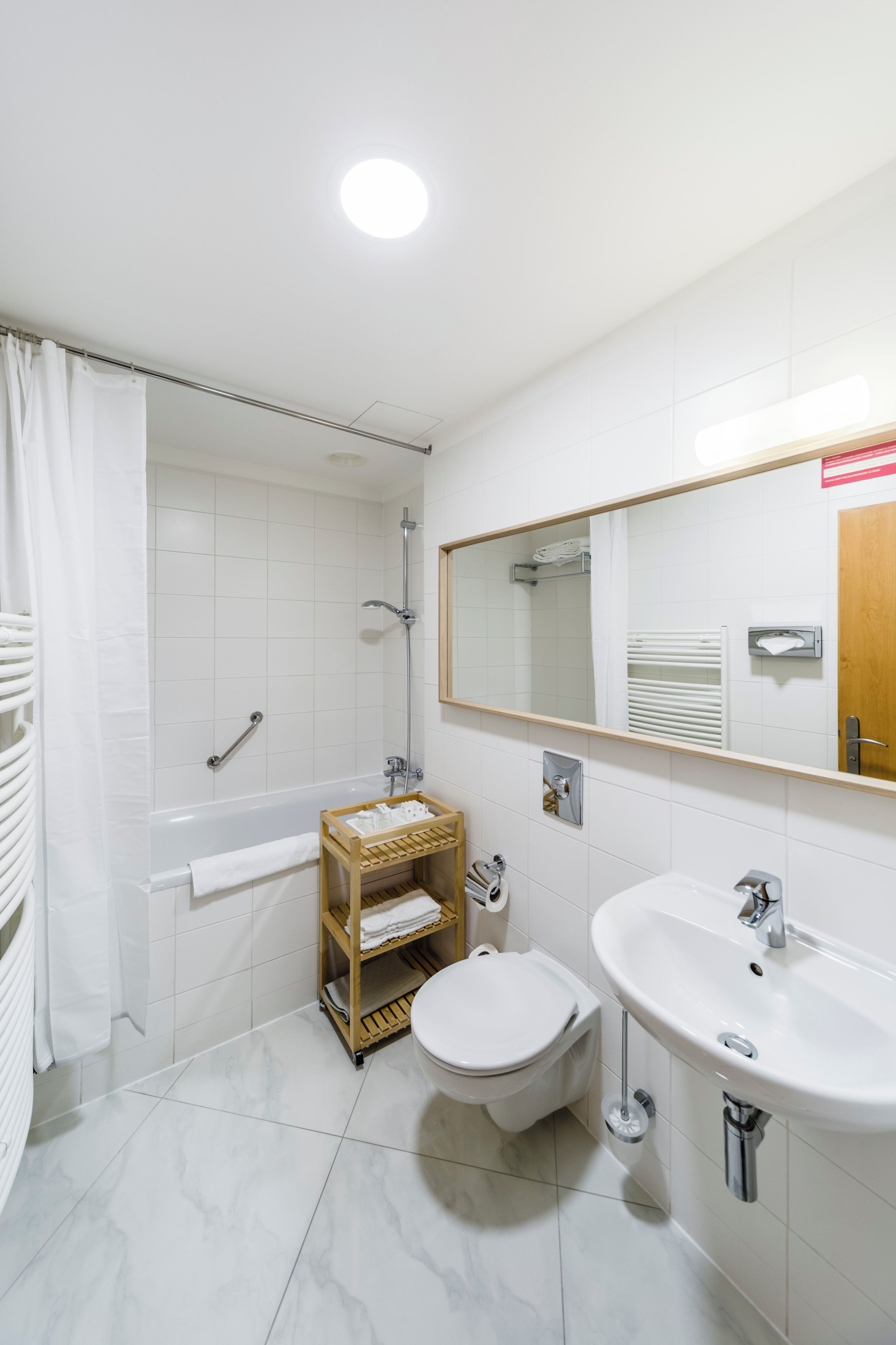 A modern bathroom with a bathtub, toilet, and sink.